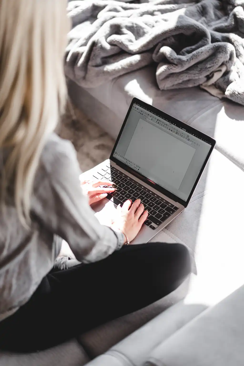 woman working on her laptop on a sofa free photo