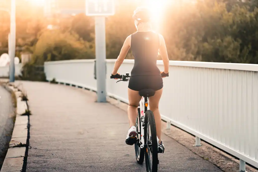 woman riding a bike during evening sun free photo