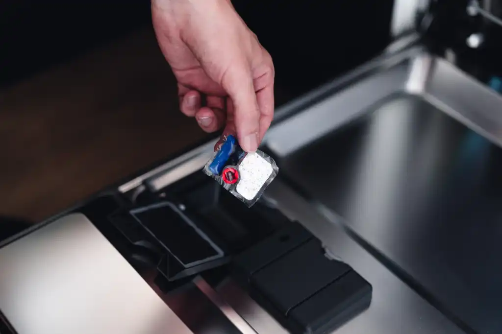 putting dishwashing capsules in a dishwasher free photo