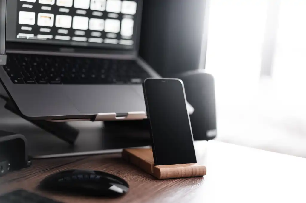 smartphone in a wooden holder apple work desk setup free photo