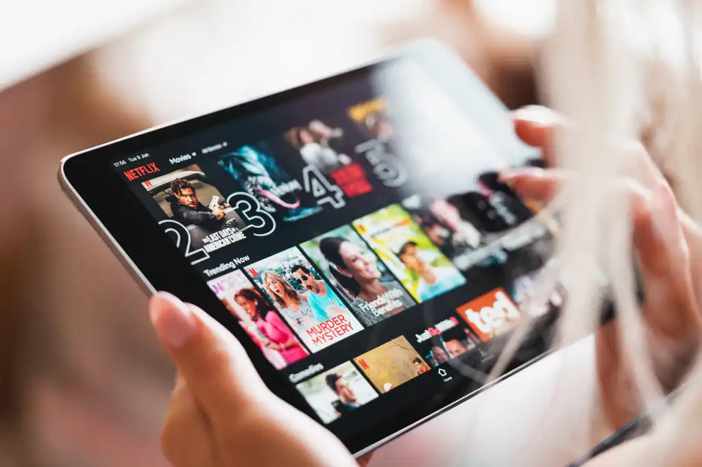 woman browsing netflix app with movies on her tablet free photo