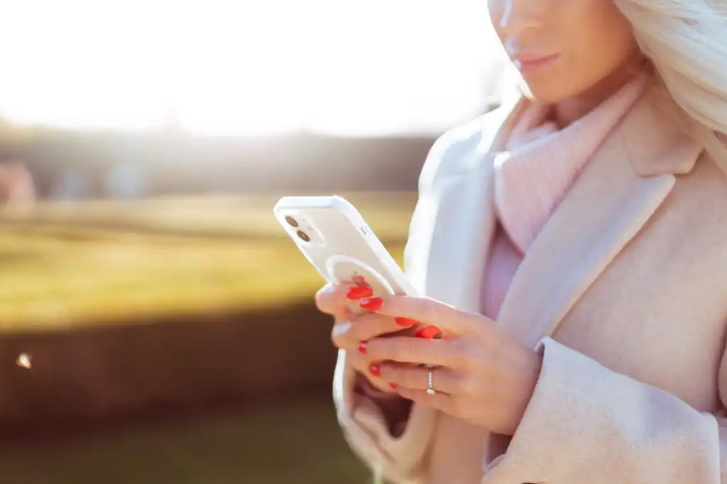 young woman in fall coat using her smartphone free image